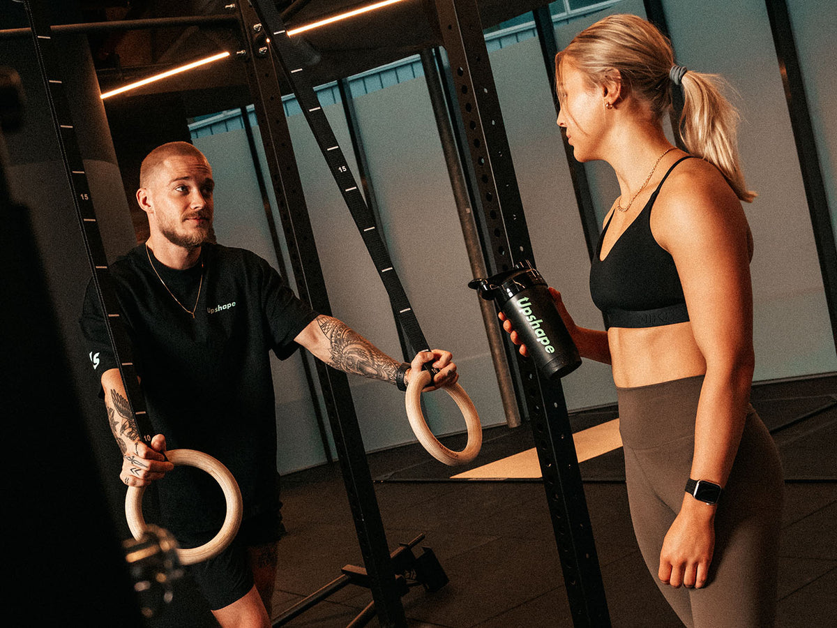 Personal trainer in gesprek met een klant in de Upshape PT-gym in Den Haag